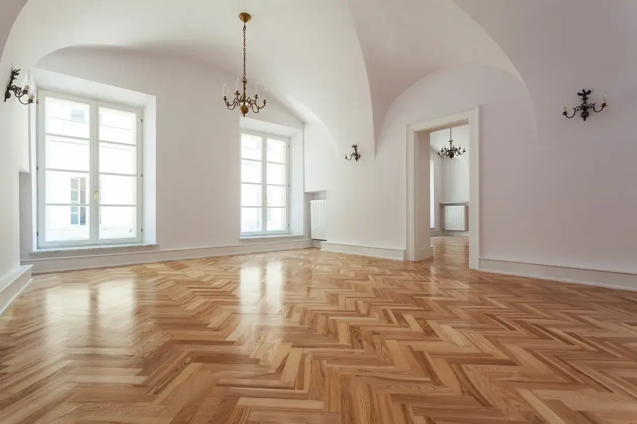 Parquet a spina di pesce lucido, pronto per la levigatura parquet fai da te. Stanze luminose con grandi finestre e lampadari antichi.