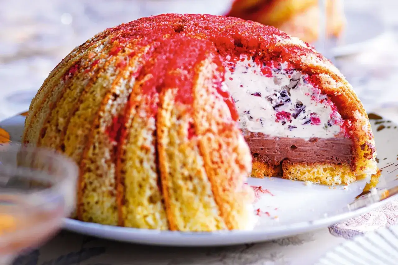 Zuccotto fiorentino, un dolce a cupola con pan di Spagna, crema e cioccolato, decorato con sciroppo rosso.