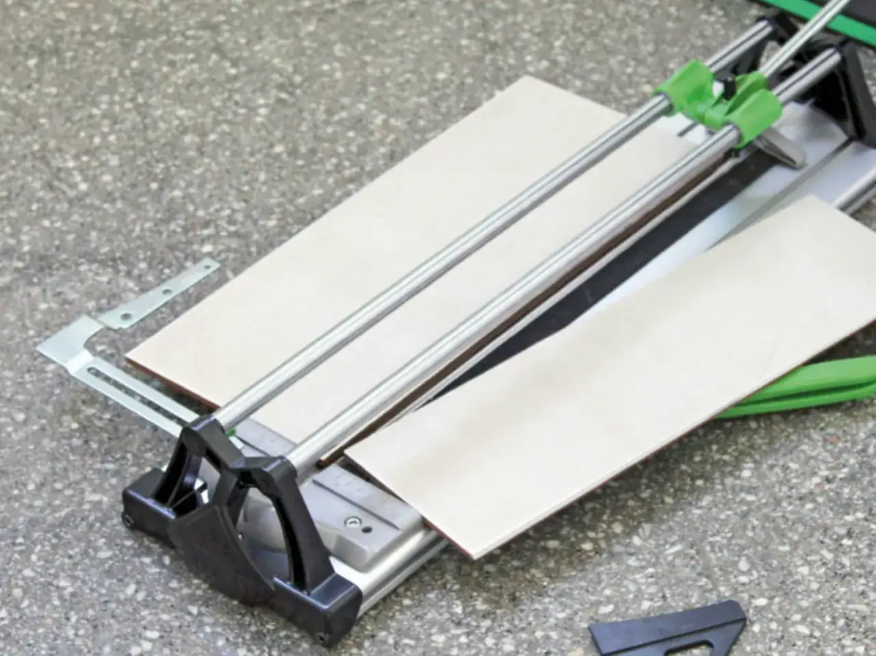 Machine de découpe de carrelage avec deux carreaux prêts à être coupés.