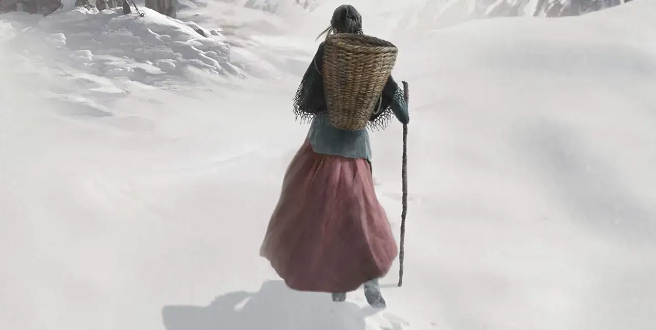 Una figura con un cesto sulla schiena e un bastone cammina su un terreno innevato, la trama del fiore di roccia si intravede tra le rocce.