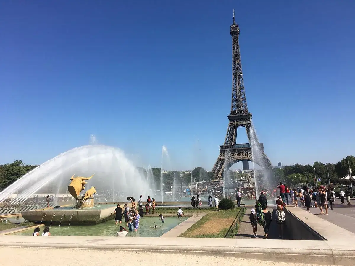 Fontaines spectaculaires devant la Tour Eiffel, avec des visiteurs profitant de l'eau près du **Palais de Chaillot**.