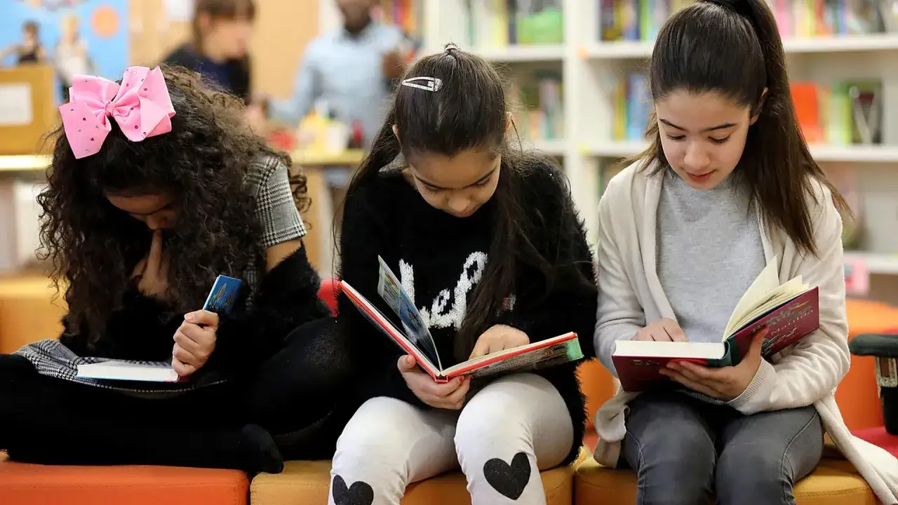 Drei M&auml;dchen lesen konzentriert B&uuml;cher. Ihre **Lesegeschwindigkeit durchschnitt** ist wahrscheinlich hoch, da sie vertieft sind.