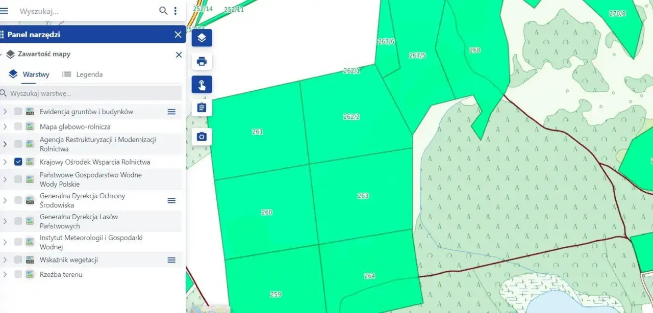 Mapa przedstawia podział działki rolnej na mniejsze parcele z numeracją, np. 261, 263, 264. Widoczne są warstwy mapy, takie jak 