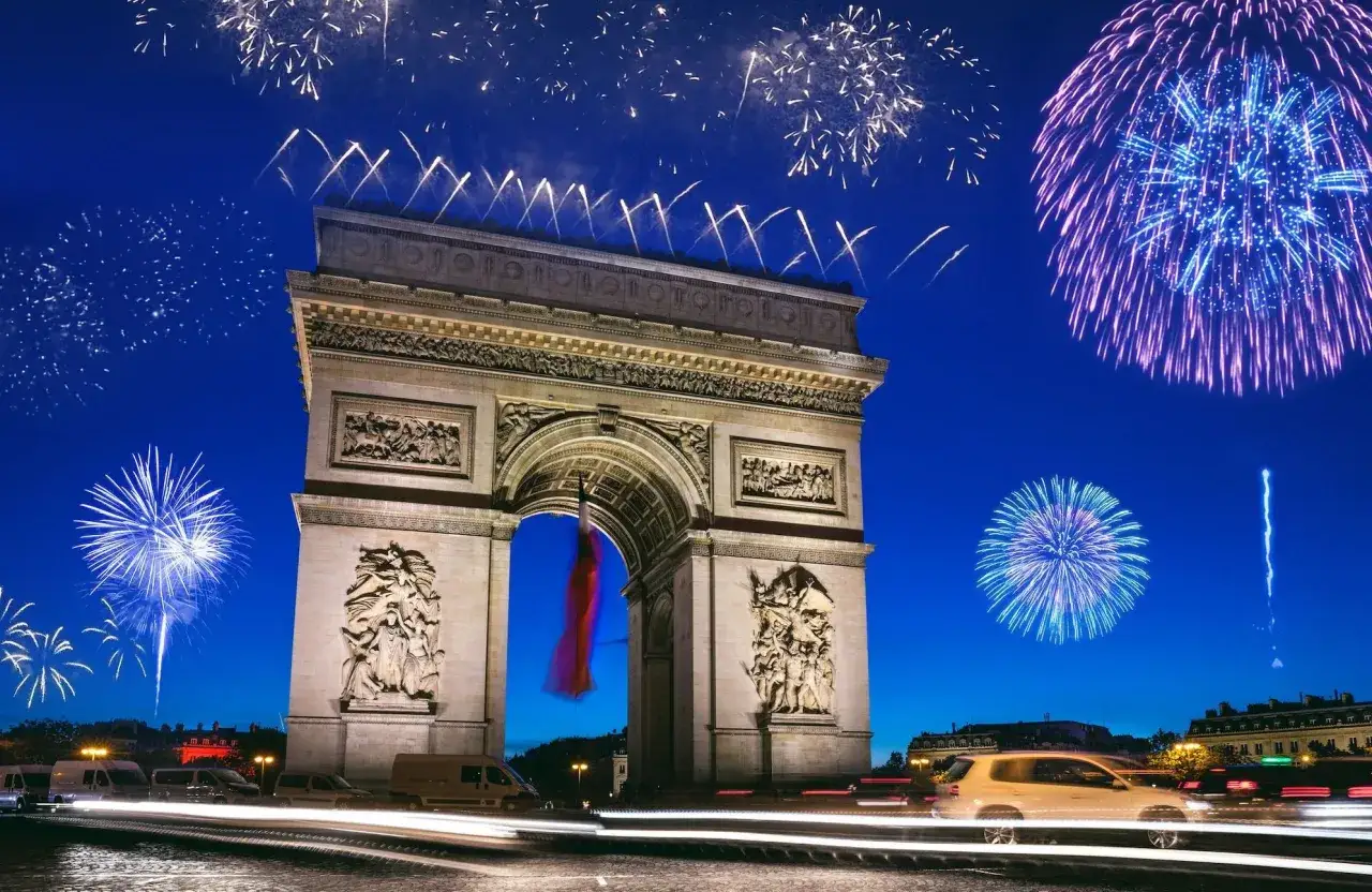Feux d'artifice éclatants illuminent le ciel nocturne au-dessus de l'Arc de Triomphe, célébrant le jour de l'an à Paris.
