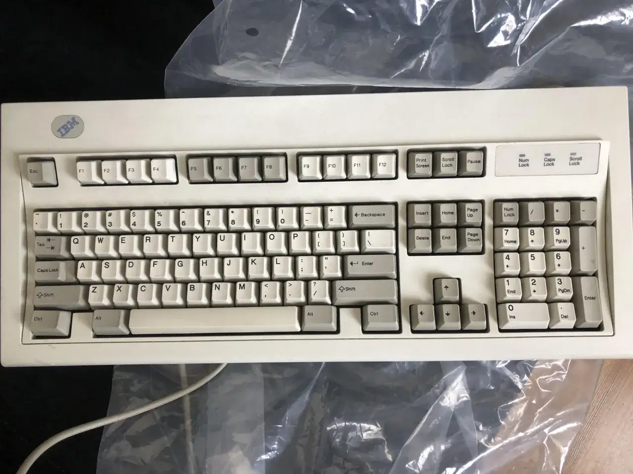 Biała klawiatura IBM z układem klawiatury QWERTY, idealna do pisania.