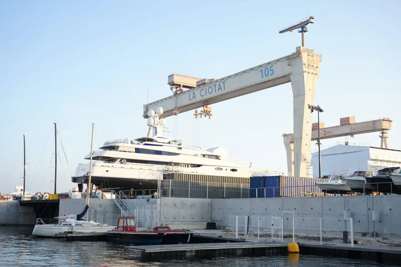 Yacht de 15 m&egrave;tres en cale s&egrave;che, sous une grue imposante. Le co&ucirc;t d'entretien d'un tel bateau est cons&eacute;quent.