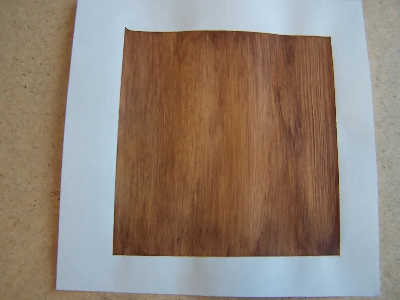 Cadre blanc sur un fond imitant le bois, prêt pour un support bois pour peinture acrylique.