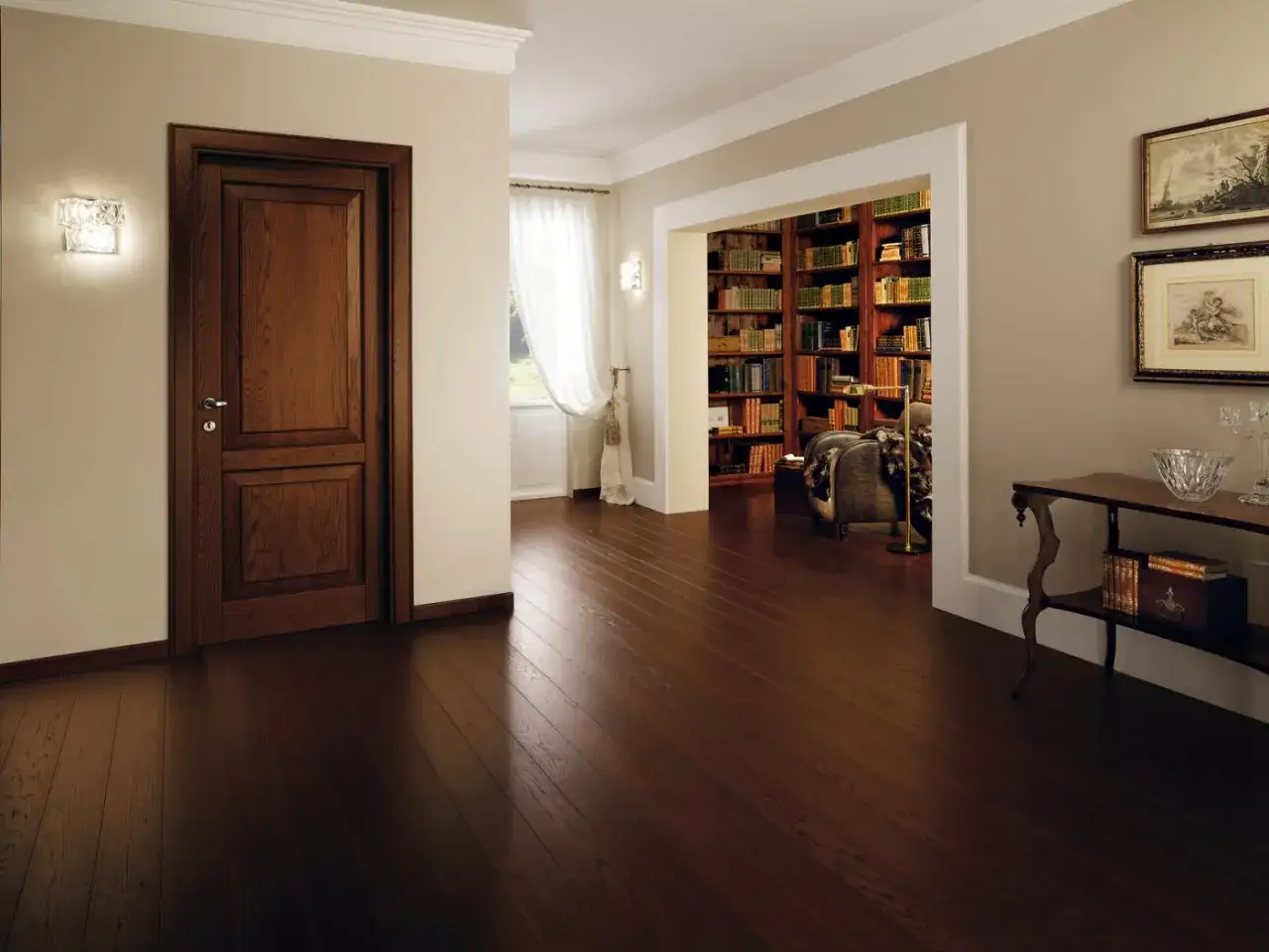 Un elegante corridoio con un battiscopa diverso dalle porte in legno scuro, che conduce a una biblioteca ricca di libri.