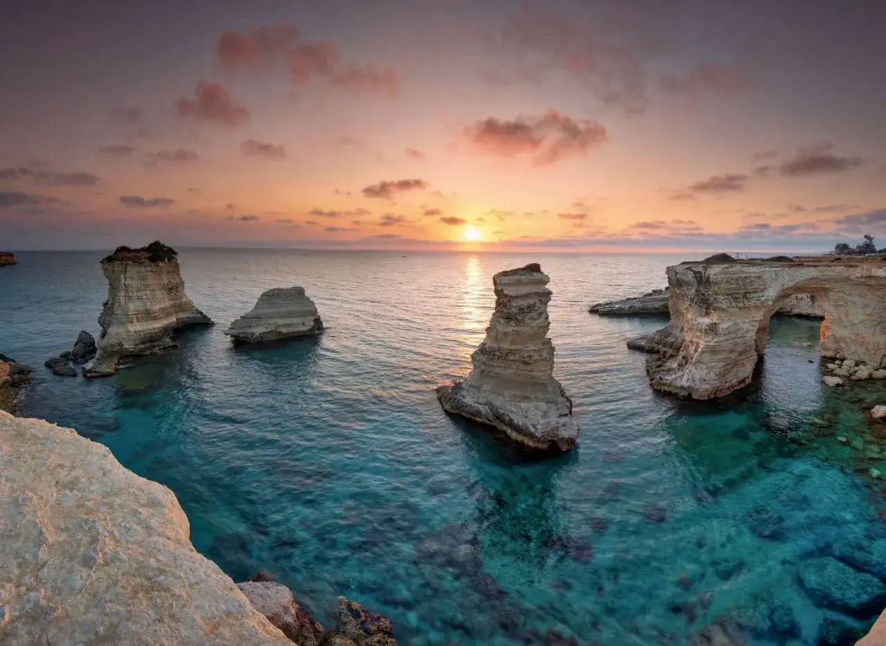 Faraglioni e mare cristallino al tramonto, un sogno per il turismo Salento.