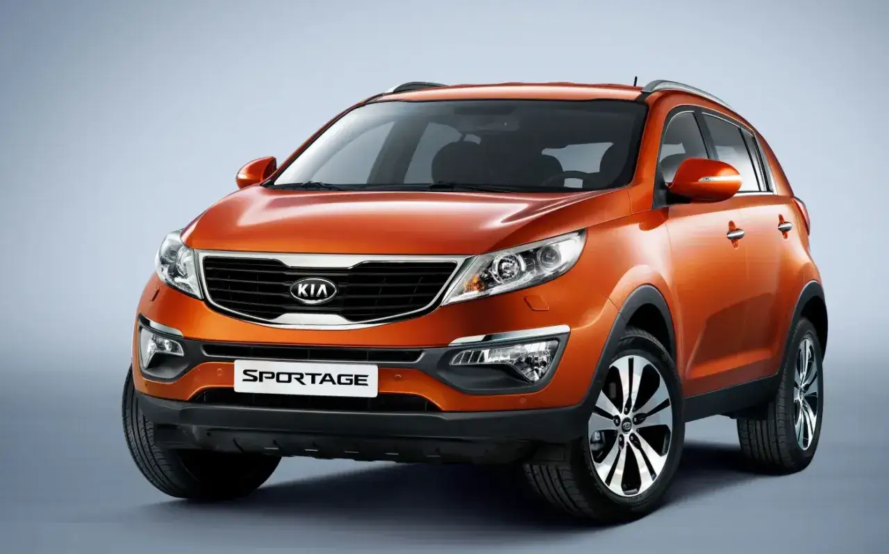 Pomarańczowy Kia Sportage 2013 z chromowanymi detalami i felgami prezentuje się dynamicznie.