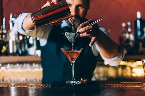 Barman w klubie nocnym przygotowujący drinka