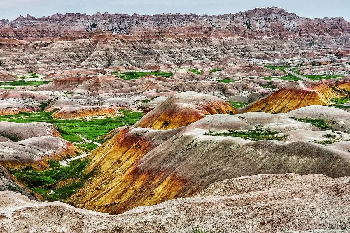 Paisaje de **carcavas** en Espa&ntilde;a, con formaciones rocosas erosionadas en tonos ocres y verdes, evocando un terreno des&eacute;rtico y salvaje.