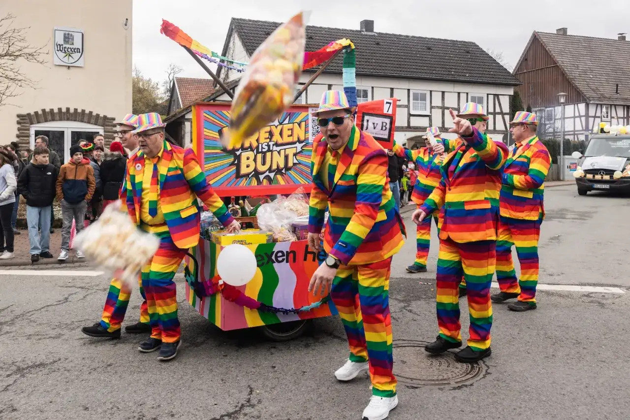 Bunte Kost&uuml;me und ein fr&ouml;hlicher Wagen bei den Karnevalstagen. Die Narren werfen S&uuml;&szlig;igkeiten.