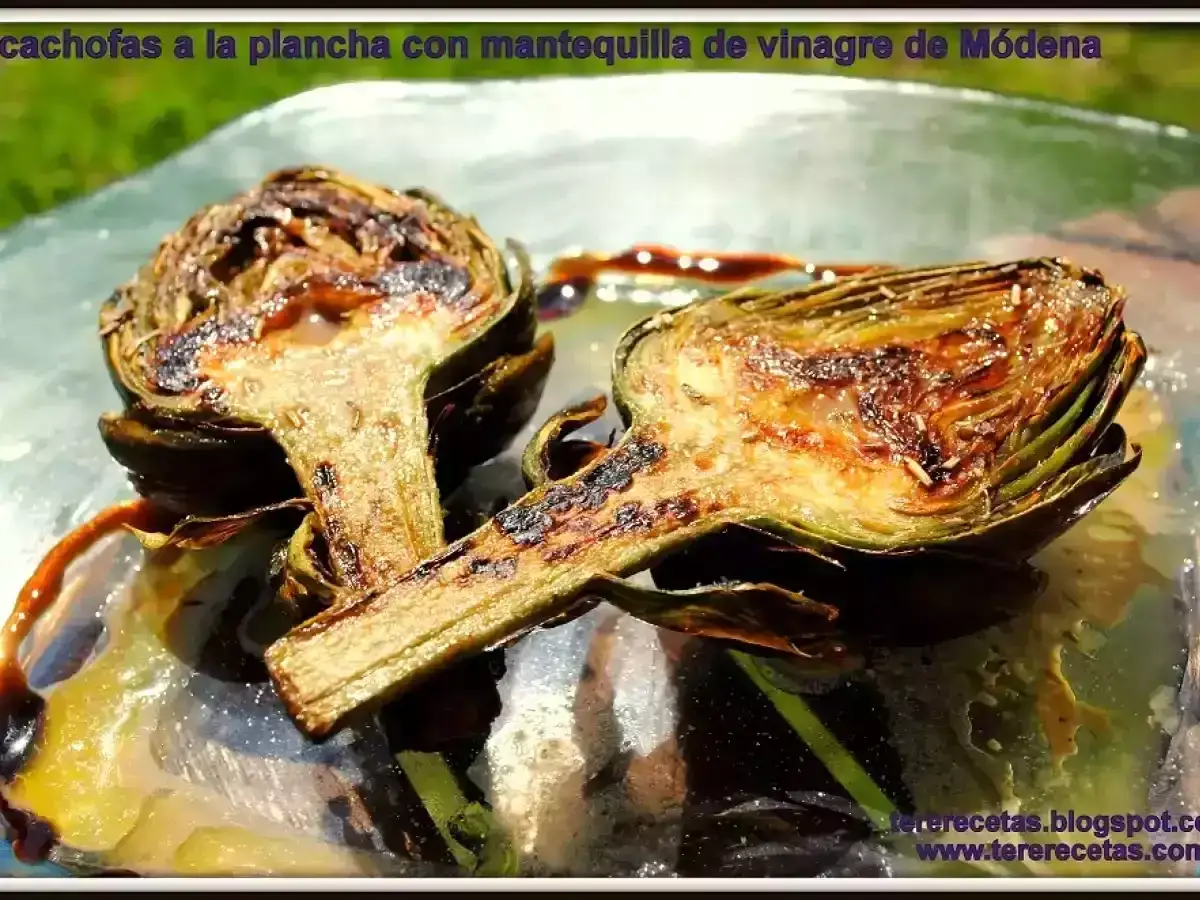 Dos mitades de alcachofas a la plancha, doradas y jugosas, con un glaseado de vinagreta de Módena.