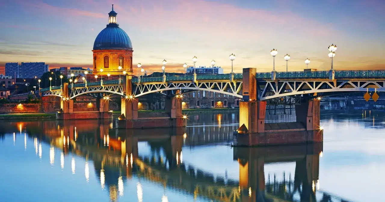 Mostek Pont Neuf w Tuluzie, z kopułą Hôtel-Dieu i odbiciem świateł w rzece Garonnie, to jedna z głównych atrakcji miasta.