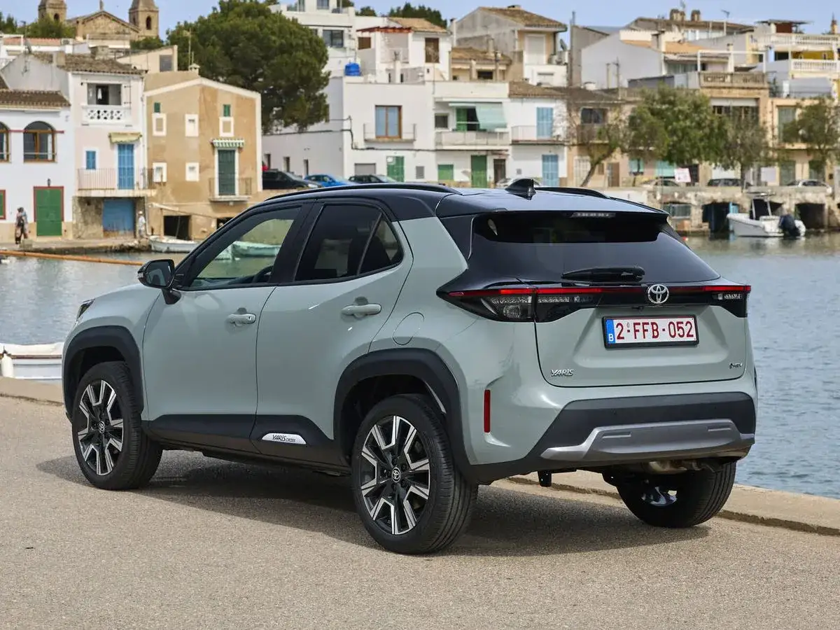 Coche gris con etiqueta eco en Catalu&ntilde;a, aparcado junto al mar en un pueblo costero.