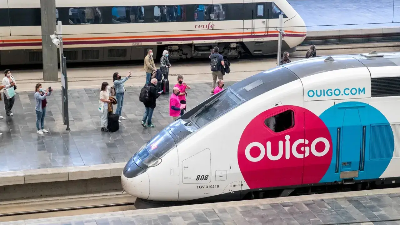 Gente espera en la estación para tomar un tren Ouigo, conectando Barcelona y Madrid.