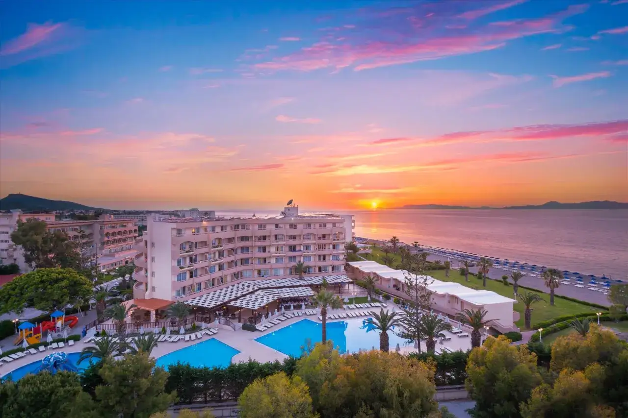 Zachód słońca nad morzem, baseny i budynki Rhodos Horizon Resort.