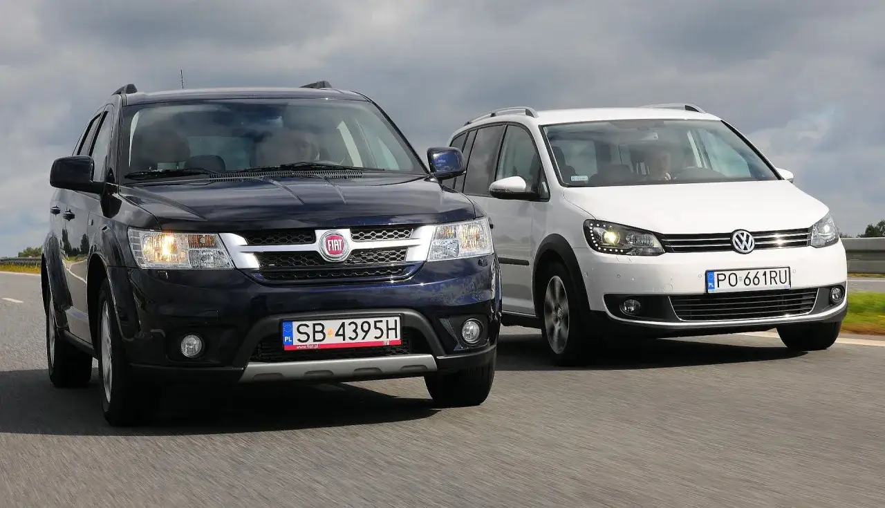 Ciemny Fiat i biały Volkswagen jadą obok siebie. Oba to najwygodniejsze samochody na długie trasy.
