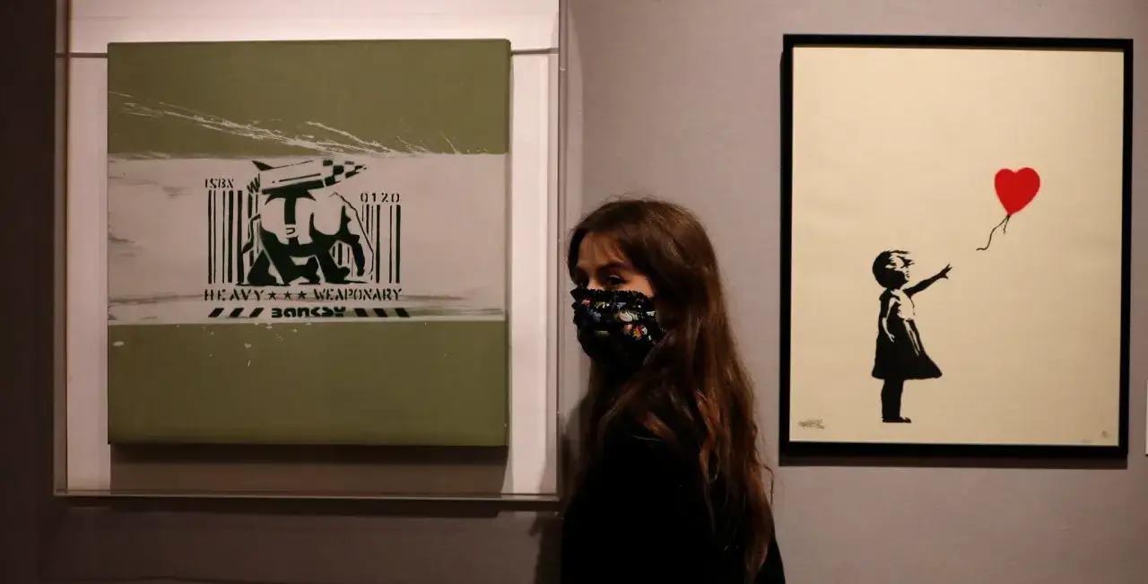 A woman in a mask views Banksy's 