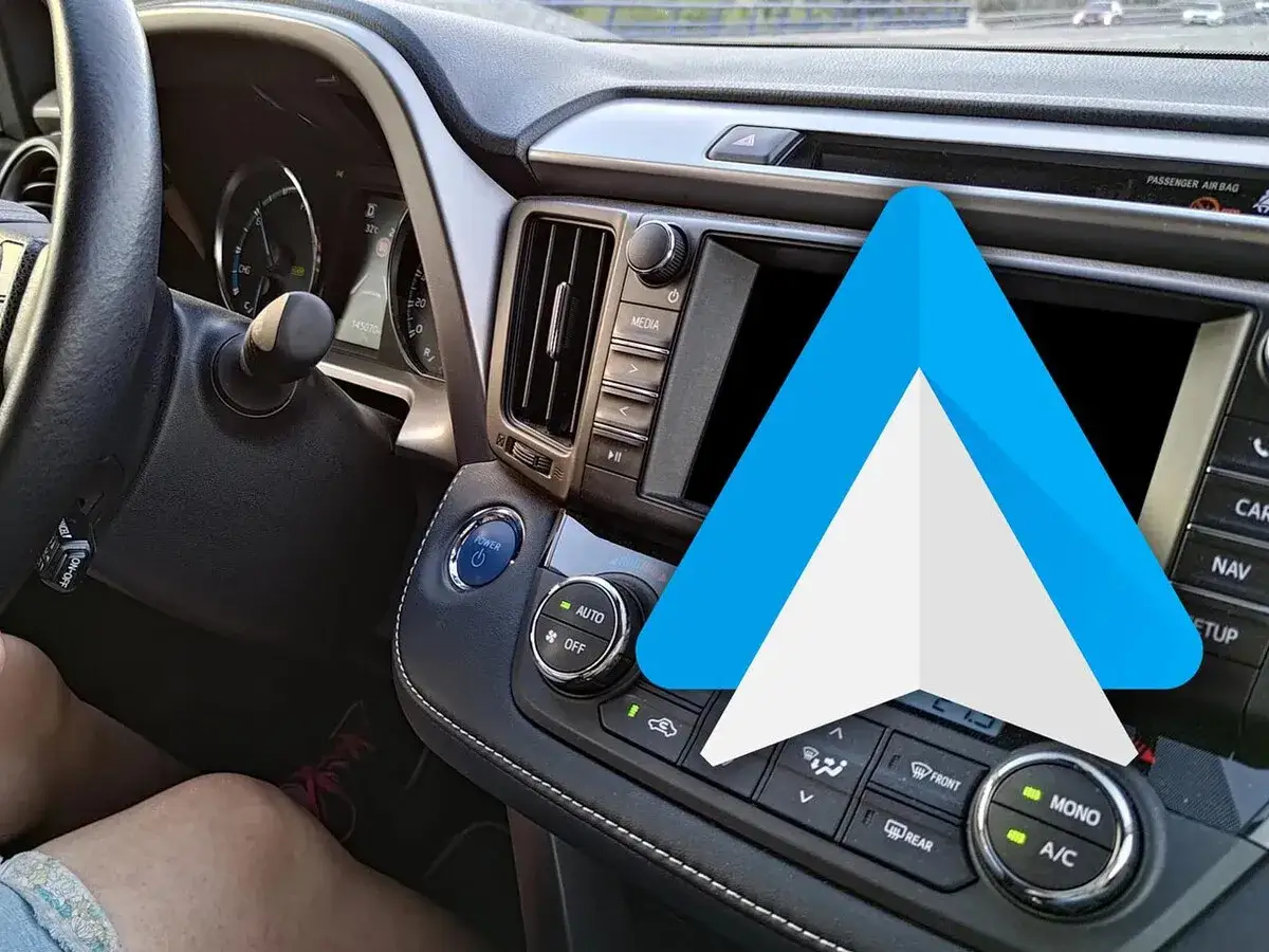 El logo de Android Auto aparece sobre el panel de un coche, listo para actualizar tu experiencia de conducción.