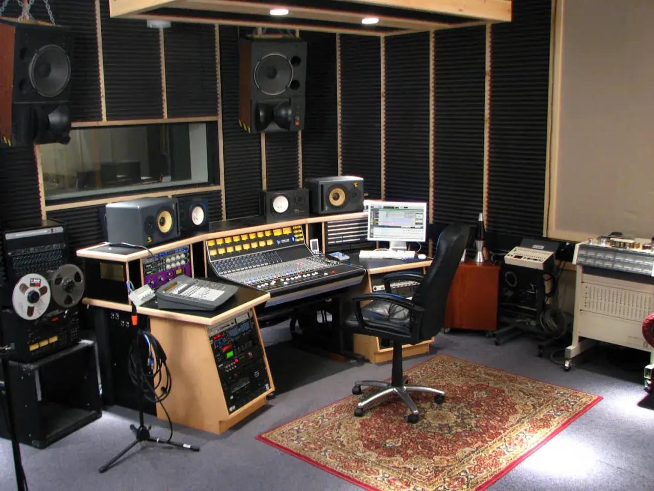 Professionelles **studio setup** mit Mischpult, Monitoren, Computer und Aufnahmegeräten.
