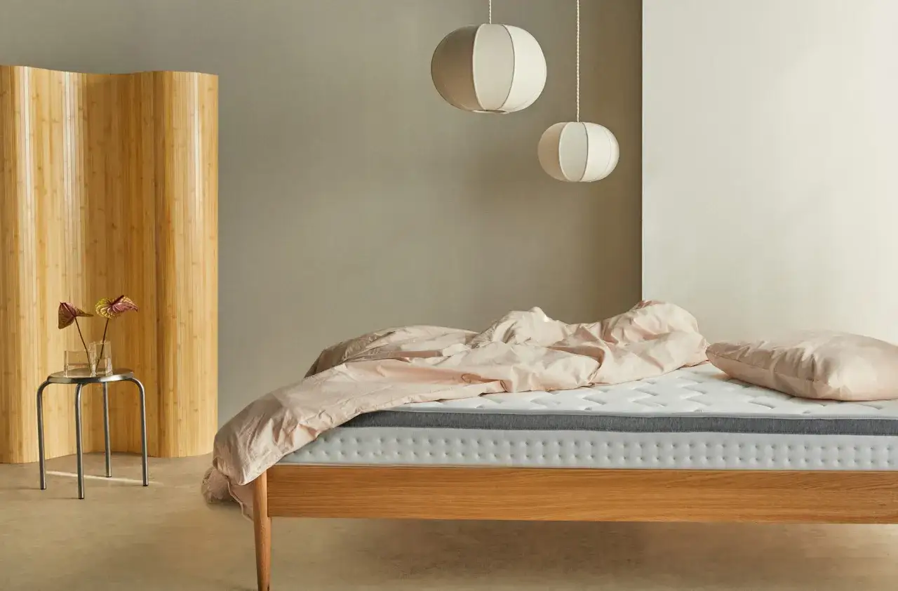 Cama de madera con ropa de cama rosa, biombo de bambú y lámparas colgantes. Ideas para decorar habitacion con estilo minimalista.