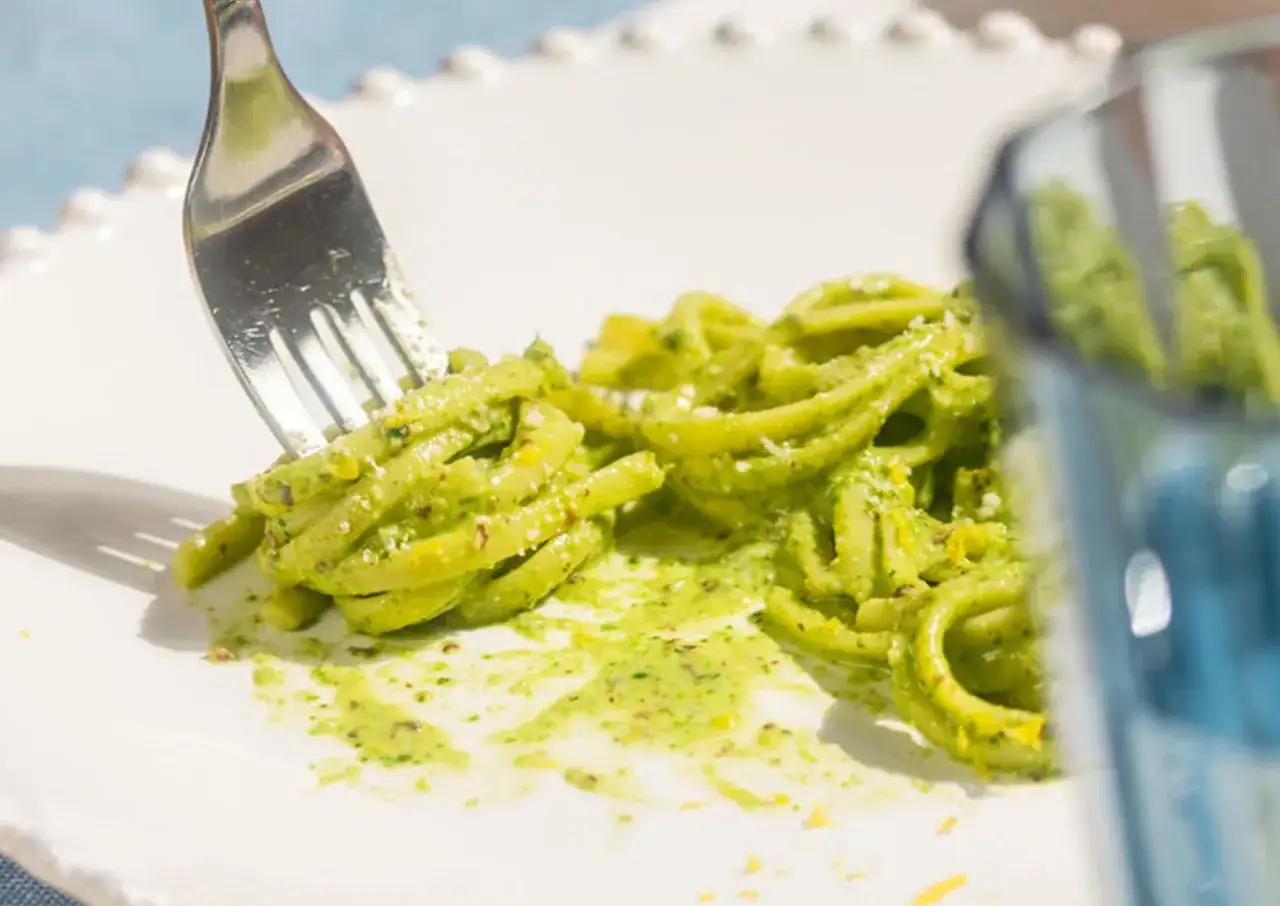 Un piatto di pasta fresca condita con un vibrante pesto al limone, pronto per essere gustato.