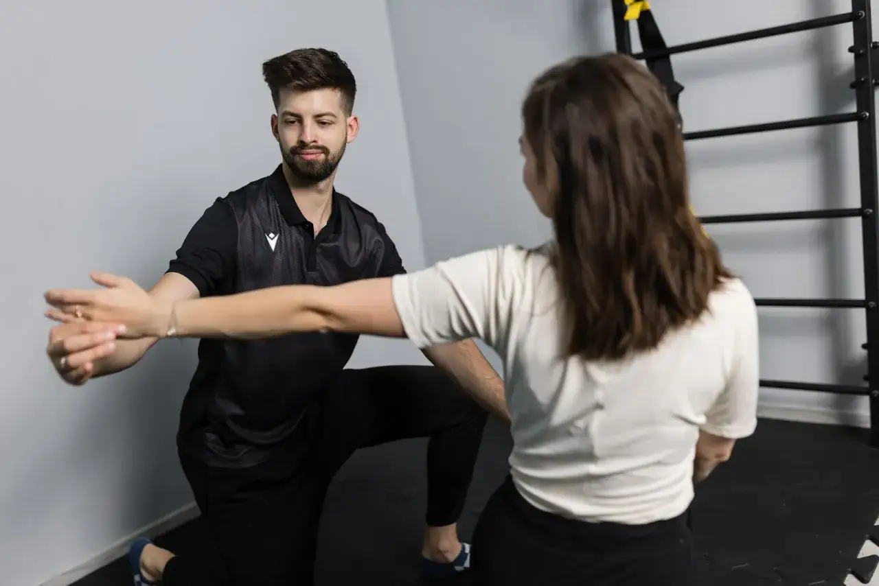 Fizjoterapeuta pomaga pacjentce z **złamanie łopatki** w ćwiczeniach rehabilitacyjnych.