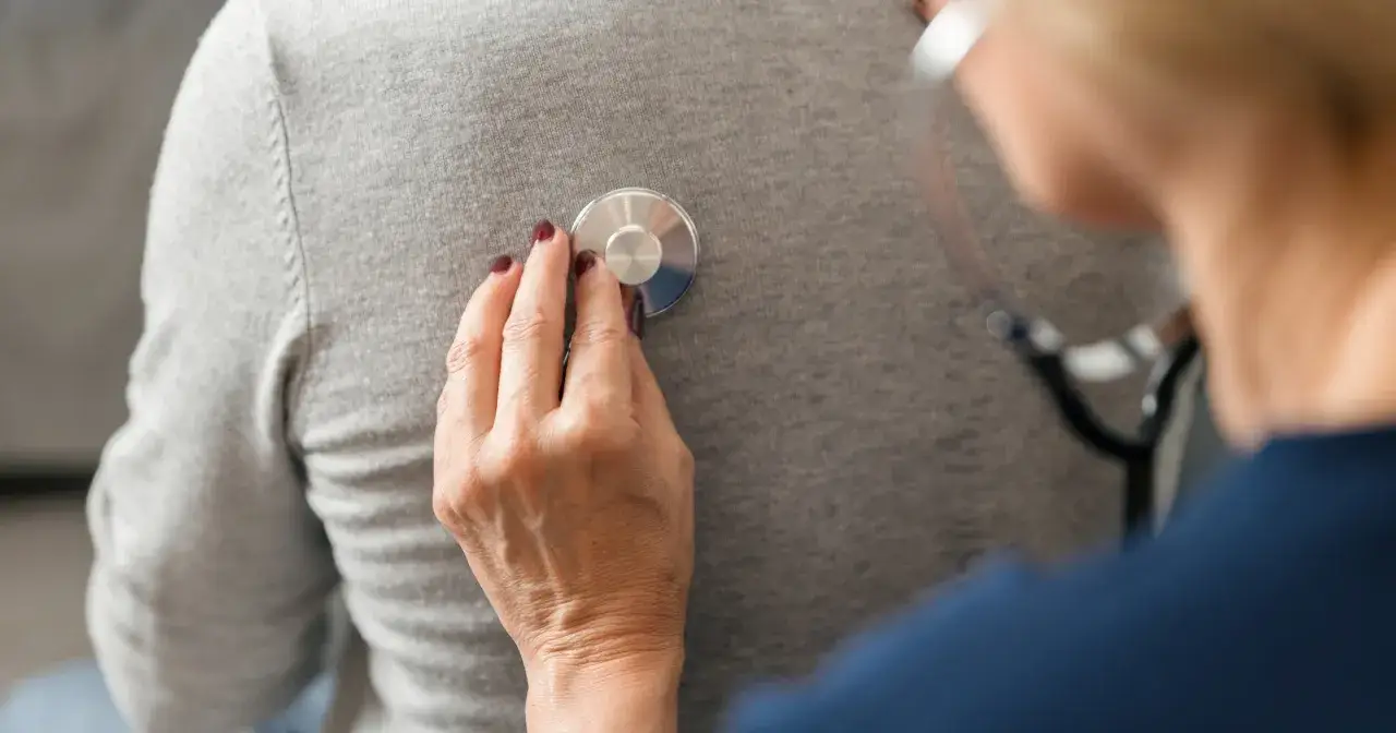 Lekarz osłuchuje pacjenta. Statyny a seniorzy – ważna kontrola zdrowia w starszym wieku.