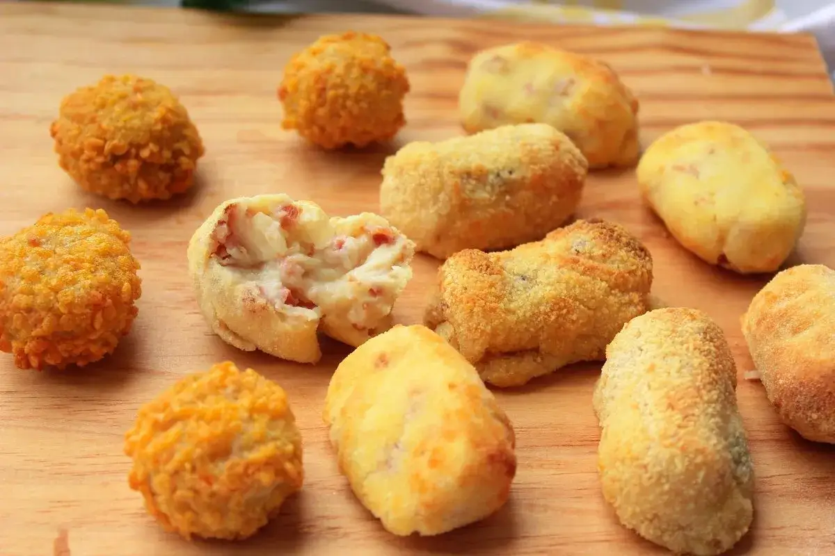 Croquetas en freidora de aire, algunas doradas y crujientes, otras con relleno cremoso de jamón. ¡Un aperitivo perfecto!