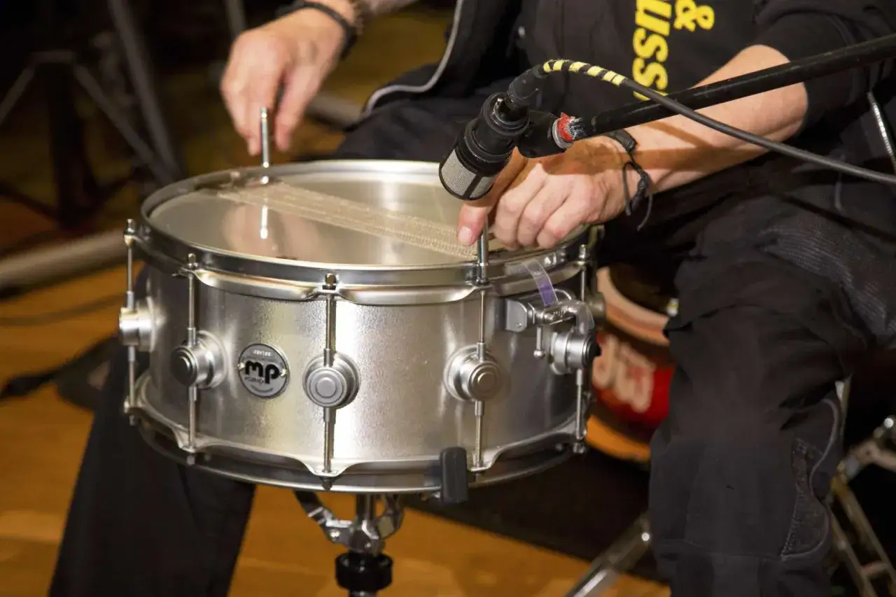 Einarmiger Schlagzeuger stimmt seine Snare Drum.