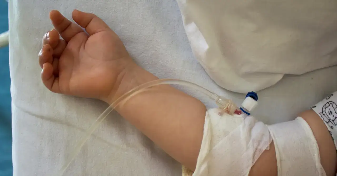 Ręka dziecka z wenflonem, przygotowana do podania leków, być może nawet smecta dla dzieci, gdy brzuszek dokucza.