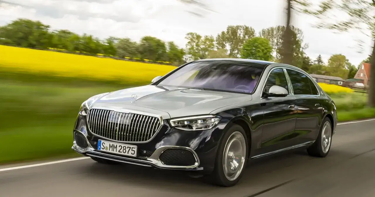 Elegancki, dwukolorowy Mercedes Maybach, najdroższy mercedes, pędzi przez kwitnące pola rzepaku.