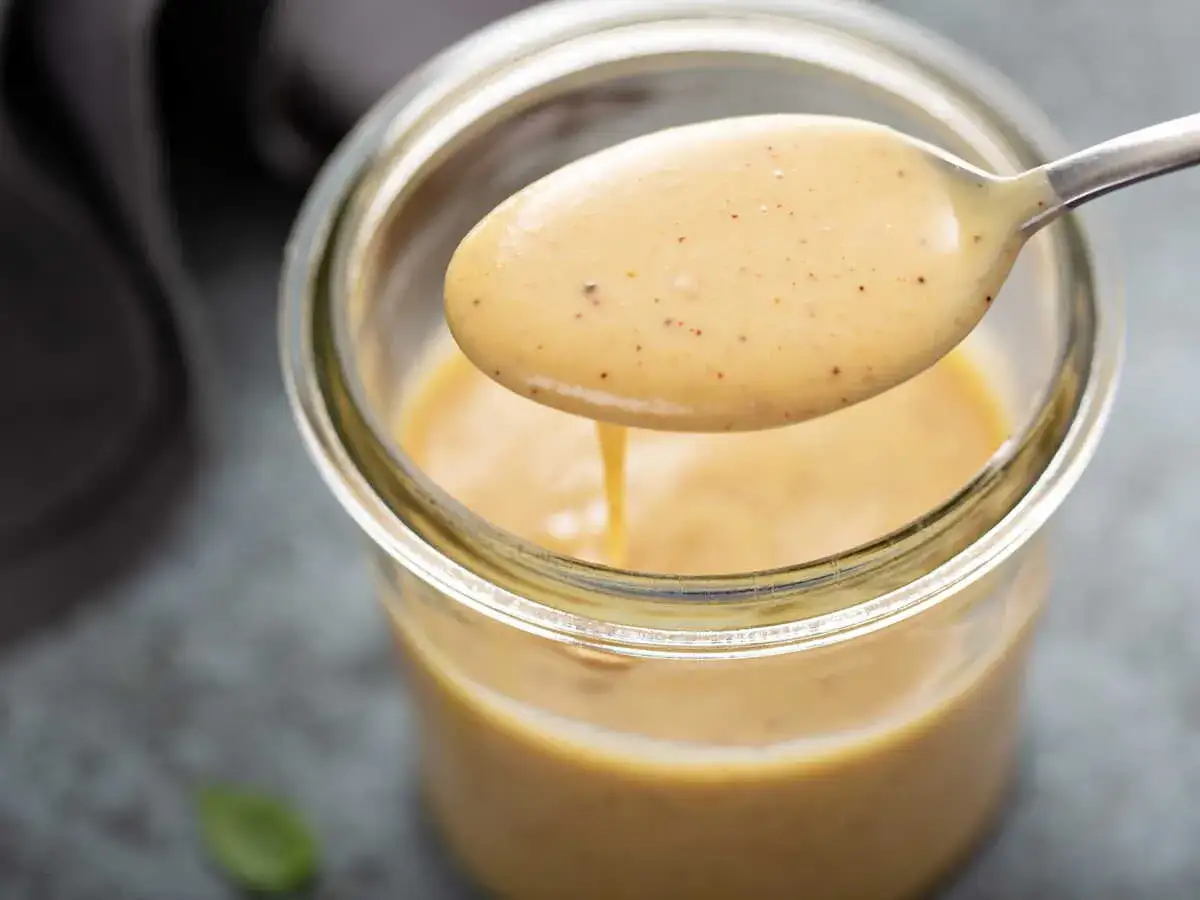 Une cuill&egrave;re d&eacute;gouline d'une onctueuse sauce moutarde miel, pr&ecirc;te &agrave; sublimer vos plats.