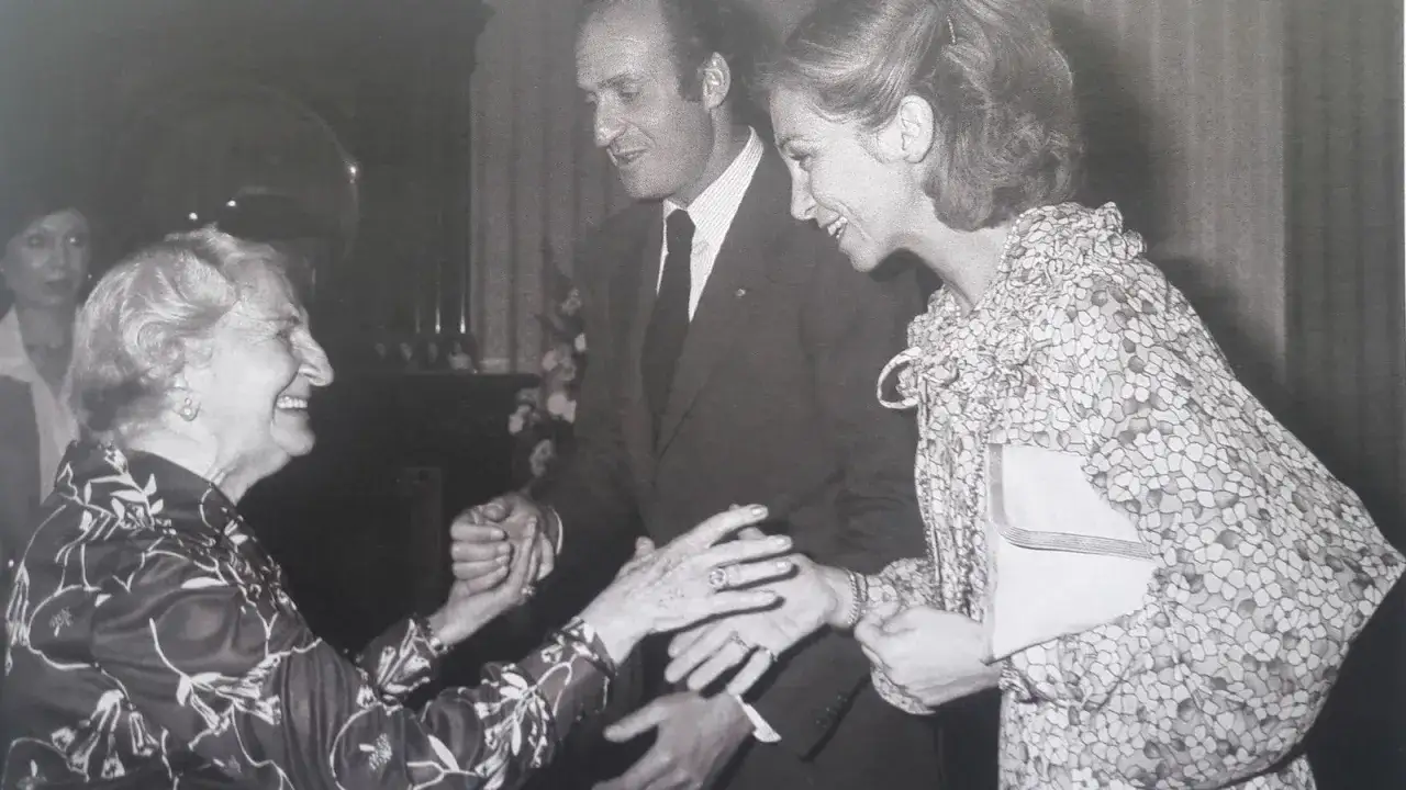 Dolores Rivas Cherif saluda sonriente al rey Juan Carlos I y a la reina Sof&iacute;a en un encuentro.