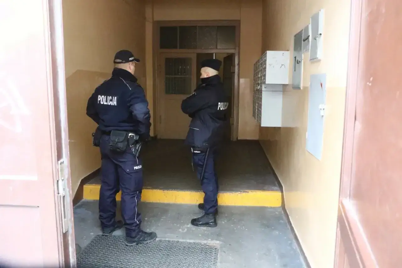 Dwóch policjantów stoi w korytarzu, pilnując porządku. Może to być związane z okresem ochronnym lokatorów.