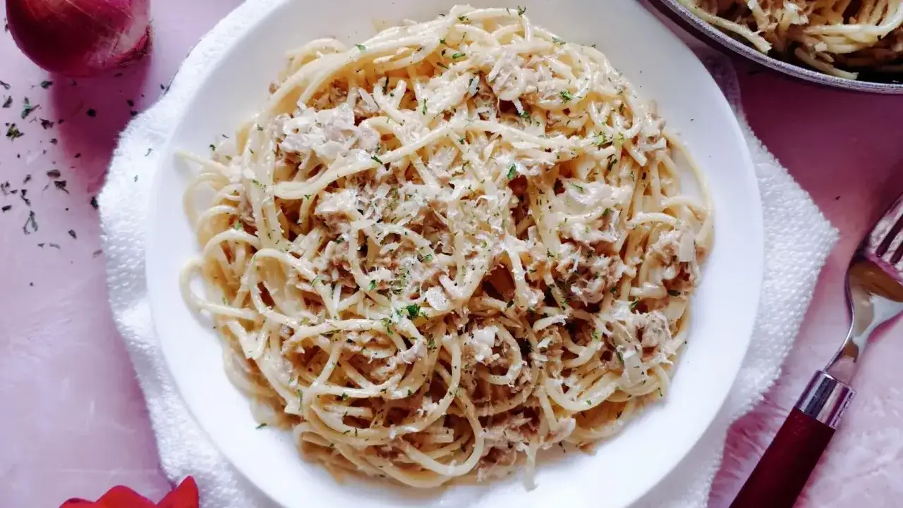 Pyszny makaron z tuńczykiem w sosie śmietanowo-serowym, posypany natką pietruszki i parmezanem. Idealny na szybki obiad.