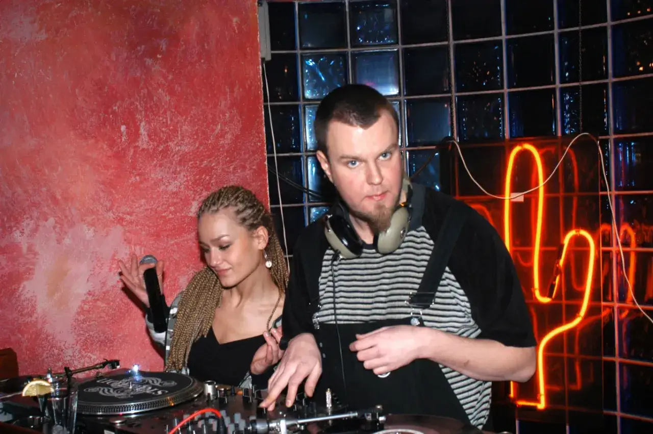 DJ Maceo Wyro i jego koleżanka przy konsoli, w tle neonowy kaktus.