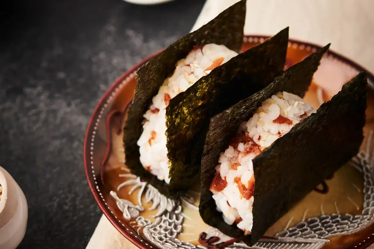 Tre onigiri avvolti in alga nori, un modo semplice per gustare questo ingrediente.
