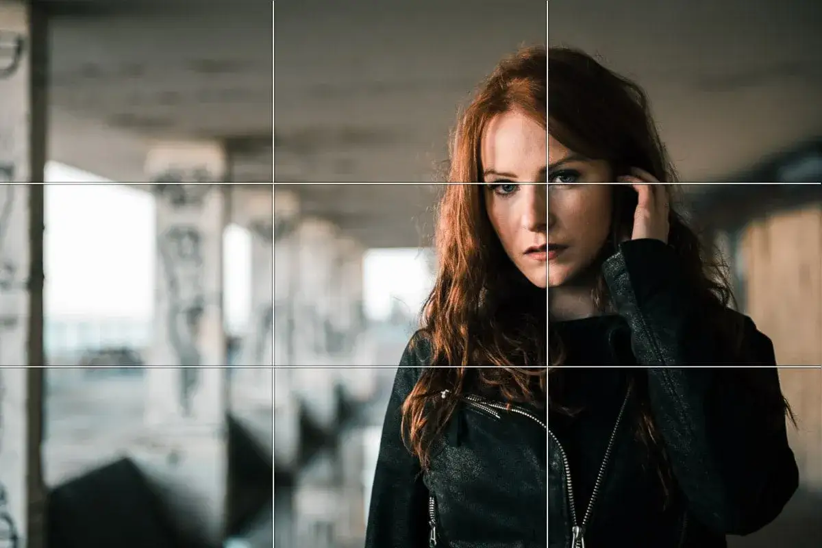 Ritratto di una donna dai capelli rossi, con lo sguardo intenso, posizionata secondo la regola dei terzi.