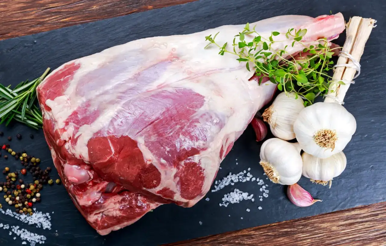 Gigot d'agneau cru, pr&ecirc;t pour une cuisson lente de 4 heures. Agr&eacute;ment&eacute; de thym, ail et poivre.