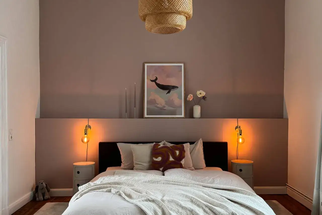 Gem&uuml;tliches Schlafzimmer mit zweifarbiger wandfarbe schlafzimmer. Ein Walbild und eine geflochtene Lampe schaffen eine beruhigende Atmosph&auml;re.