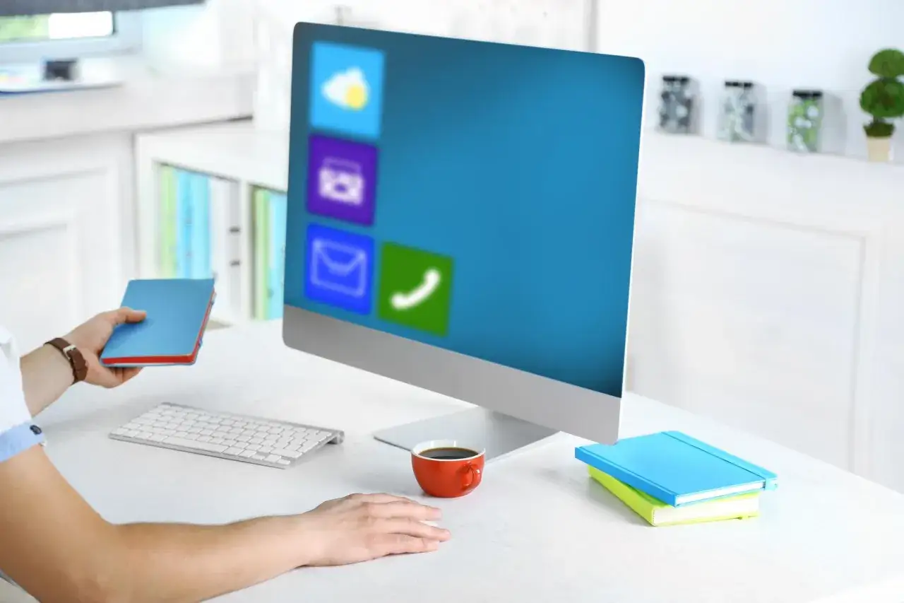 Pracownik zastanawia się, czy WPS Office jest bezpieczny, przeglądając ikony aplikacji na ekranie komputera.