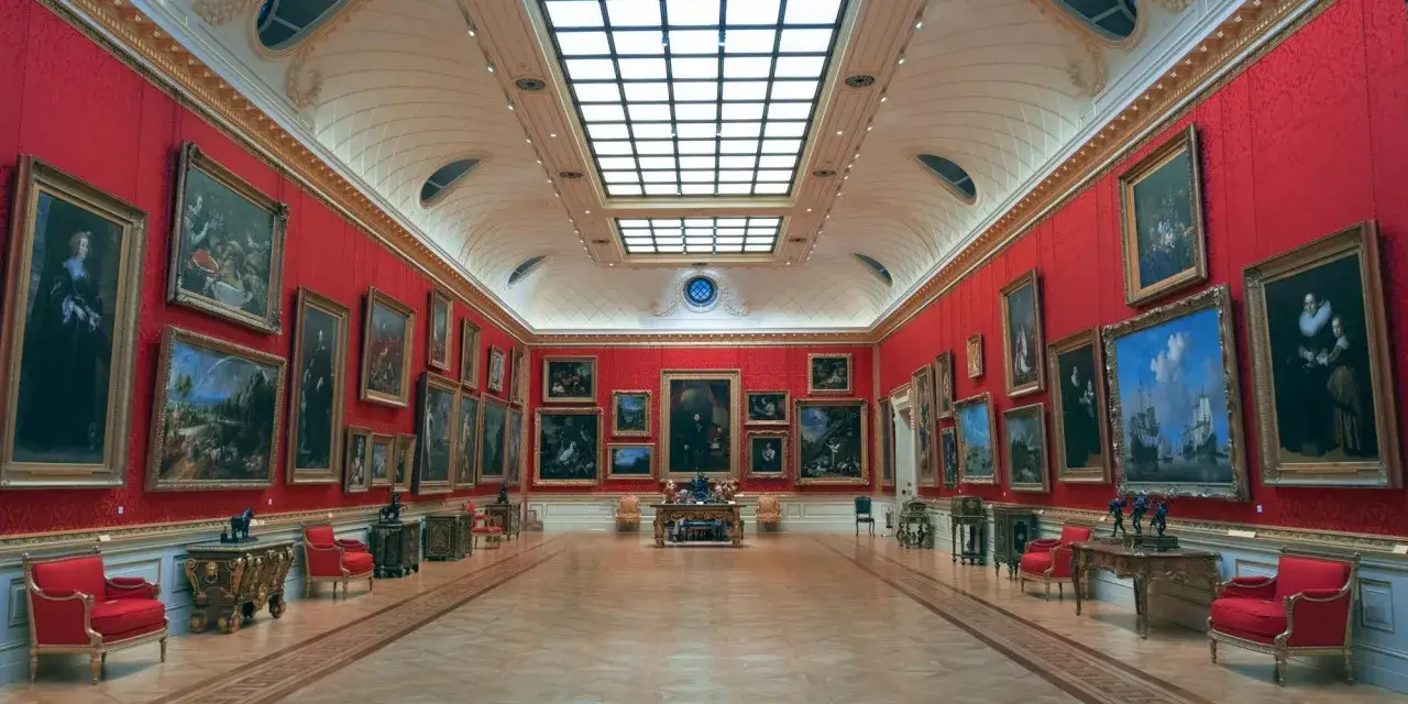 Ett storslaget galleri med r&ouml;da v&auml;ggar, fyllda med gamla tavlor. Perfekt f&ouml;r en gratis museumupplevelse i Uppsala.