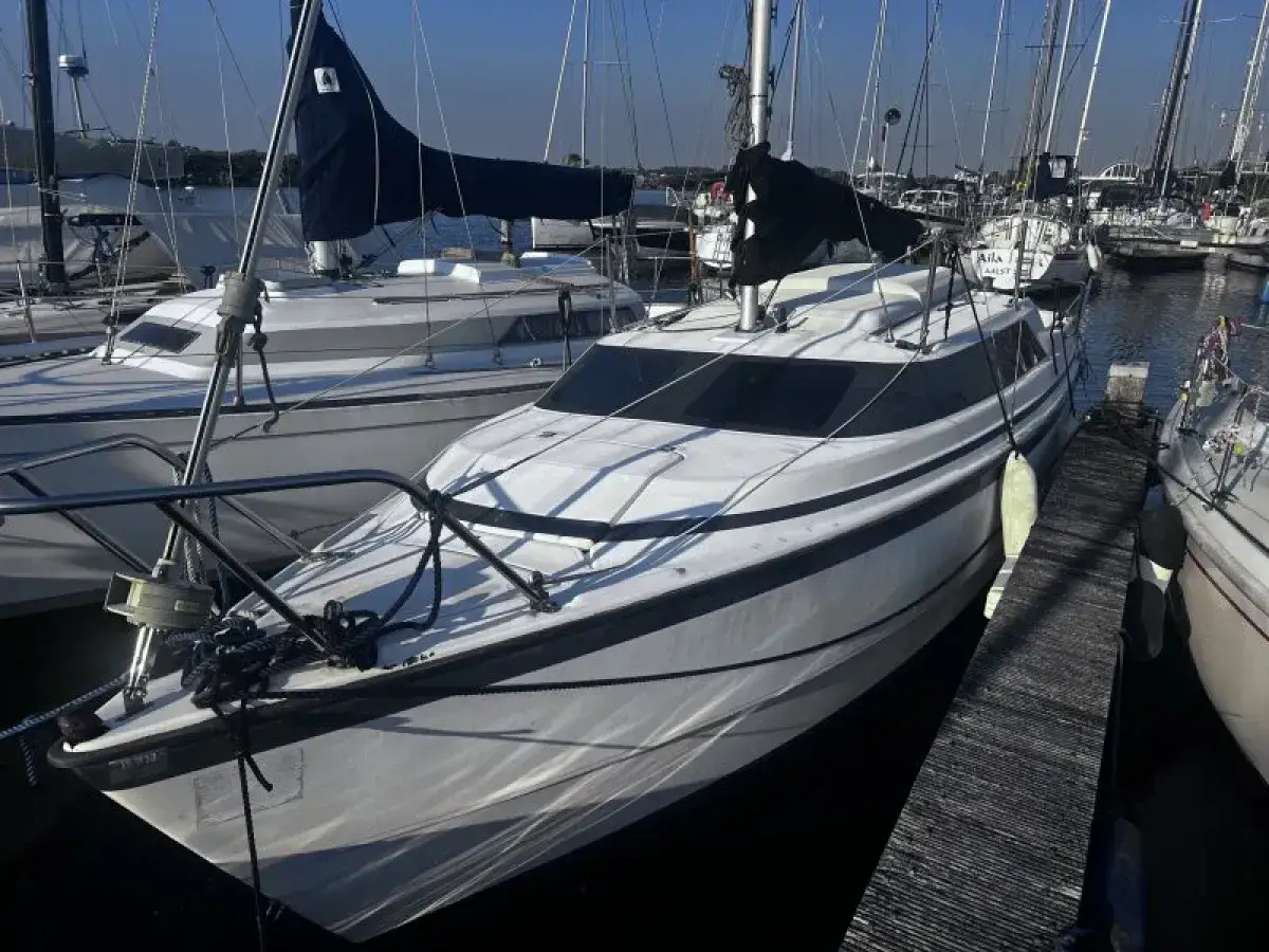 Voilier blanc, prêt pour l'aventure, avec une voile noire et le nom