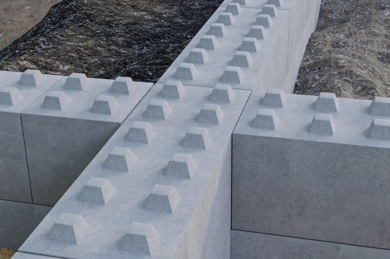 Solidny mur oporowy z bloczków betonowych, tworzący stabilną konstrukcję.