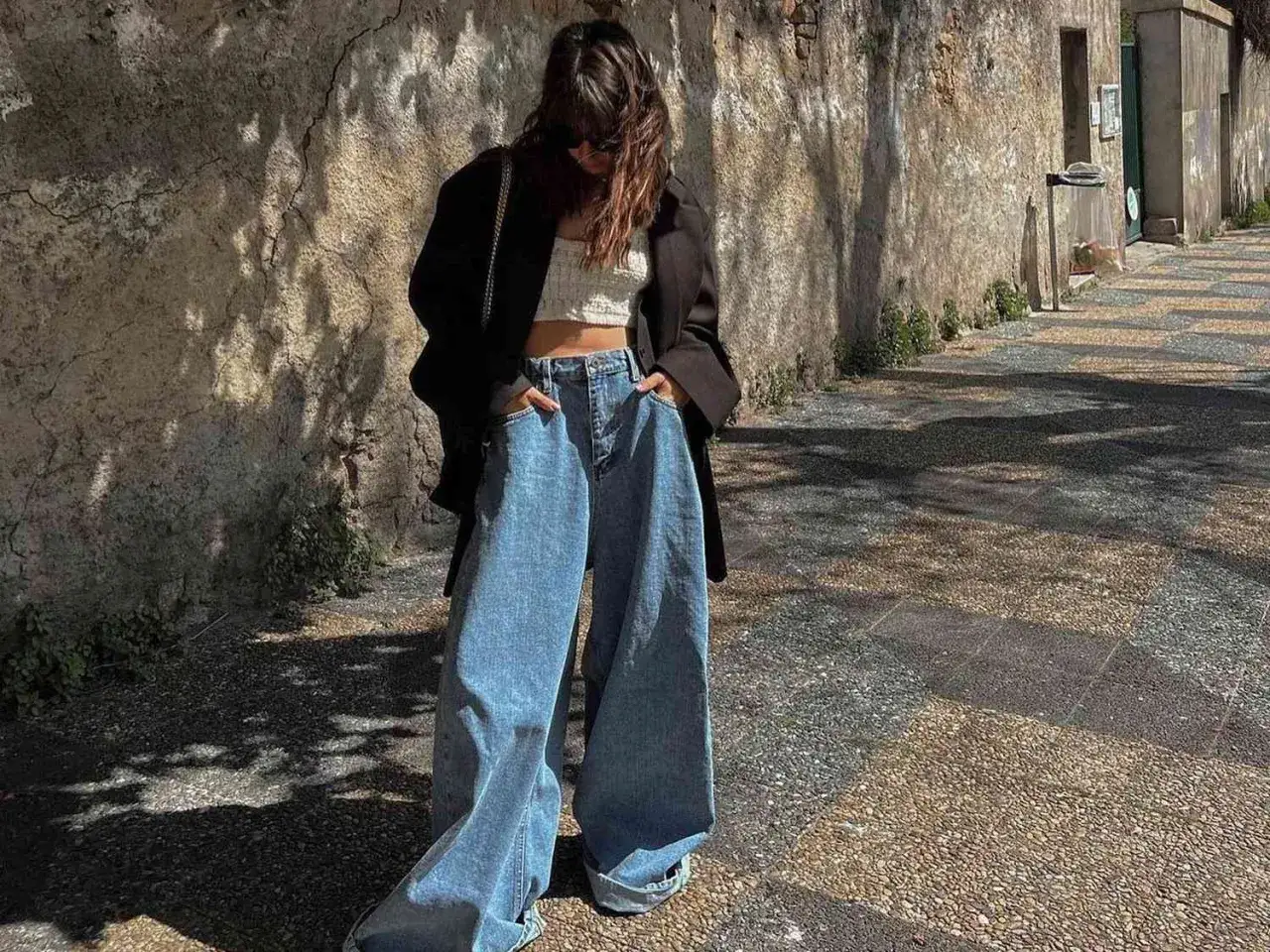 Dziewczyna w szerokich jeansach i krótkim topie, prezentująca swój ootd co to za styl.