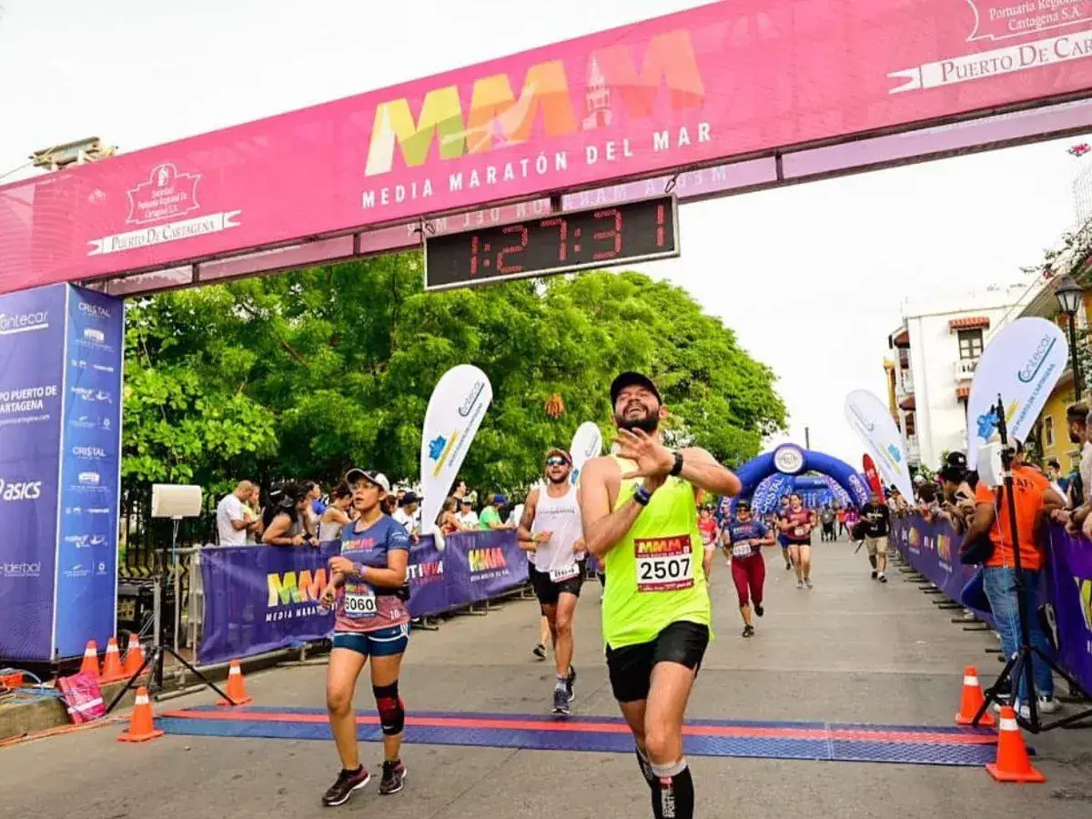 Corredores cruzan la meta de la distancia media marat&oacute;n en Cartagena. El tiempo marca 1:27:31.