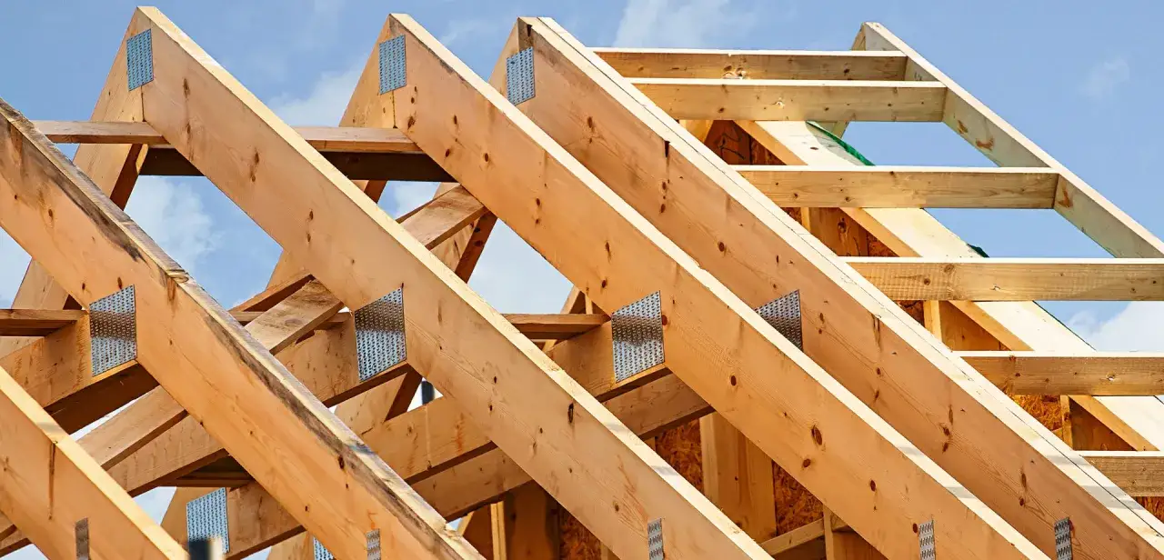 Struttura in legno di un tetto in costruzione, con travi e capriate assemblate con precisione.